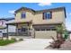 Lovely tan two-story home with covered front porch and 2-car garage plus stone accents and landscaping at 5336 Trails Edge Ln, Castle Rock, CO 80104