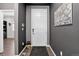 Clean, painted foyer with dark gray walls, light wood floor, modern light fixtures, and a white door at 5336 Trails Edge Ln, Castle Rock, CO 80104