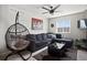 A living room provides a sofa, coffee table, a hanging chair, ceiling fan, and a window at 5336 Trails Edge Ln, Castle Rock, CO 80104
