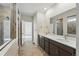 Bathroom with double sink vanity, tile floors, modern finishes, large mirror, and a separate shower with glass door at 9374 Quartz St, Arvada, CO 80007