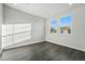 Bright bedroom featuring two large windows, neutral walls, and dark wood flooring, offering a serene living space at 9374 Quartz St, Arvada, CO 80007