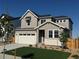 Charming two-story home featuring a well-manicured lawn, a two-car garage, and a welcoming facade at 9374 Quartz St, Arvada, CO 80007