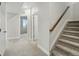 Hallway with gray carpet leading to a bedroom, staircase, and other rooms at 9374 Quartz St, Arvada, CO 80007