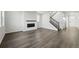 Open-concept living area featuring hardwood floors, a modern fireplace, and a staircase leading to the upper level at 9374 Quartz St, Arvada, CO 80007