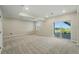 Bright living room featuring neutral carpeting, recessed lighting, and sliding glass door with backyard access and scenic views at 9374 Quartz St, Arvada, CO 80007