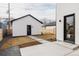 Backyard with a detached garage, modern siding, and a concrete patio with grass at 4135 Benton Street, Denver, CO 80212