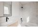 Bathroom with white tiled walls, modern fixtures, a framed mirror, and a light wood vanity at 4135 Benton Street, Denver, CO 80212