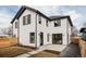 Modern two-story home with black trim, white stucco, and a spacious backyard patio at 4135 Benton Street, Denver, CO 80212