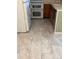 Kitchen area view showcases tiled floor, refrigerator, double oven and stained cabinets at 8731 Dawson St # 102, Denver, CO 80229