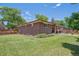 Spacious backyard with brick home, covered patio, and a large grassy area, perfect for outdoor activities at 1774 S Dover Way, Lakewood, CO 80232