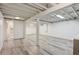 Finished basement showcasing a gray laminate floor and an open area leading to a bathroom at 1774 S Dover Way, Lakewood, CO 80232