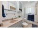 Well-lit bathroom with blue-gray cabinets, tan countertop and a neutral colored toilet at 1774 S Dover Way, Lakewood, CO 80232