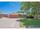Charming single-story brick home with a well-maintained lawn and mature landscaping at 1774 S Dover Way, Lakewood, CO 80232