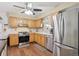 Kitchen with stainless steel appliances, wood cabinets, and durable hardwood floors at 1774 S Dover Way, Lakewood, CO 80232
