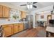 A fully equipped kitchen features light oak cabinets, a stainless-steel refrigerator, and access to a bar style dining area at 1774 S Dover Way, Lakewood, CO 80232