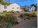 Home features a charming front yard with drought-tolerant landscaping, stone pathway, and cozy curb appeal at 4374 S Washington St, Englewood, CO 80113