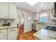 Well-lit kitchen showcasing white cabinets, granite countertops, and stainless steel appliances with an adjacent dining room view at 4374 S Washington St, Englewood, CO 80113