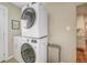 Laundry room with stacked appliances and storage adjacent to the kitchen at 4374 S Washington St, Englewood, CO 80113