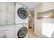 Modern laundry room featuring stacked washer and dryer and ample storage at 4374 S Washington St, Englewood, CO 80113