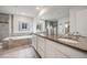 Bathroom features a dual sink vanity, a soaking tub, and a glass-enclosed shower at 10387 Harrisburg St, Parker, CO 80134