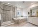Bright bathroom featuring a tiled shower with glass door, soaking tub, and vanity with granite countertop at 10387 Harrisburg St, Parker, CO 80134