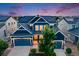 Beautiful two-story navy blue home showcasing a three-car garage and solar panels at 10387 Harrisburg St, Parker, CO 80134