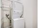 Compact laundry room with stacked washer and dryer and a metal storage rack at 10387 Harrisburg St, Parker, CO 80134