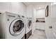 Bright laundry room with washer, dryer, and utility sink at 10387 Harrisburg St, Parker, CO 80134