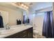 Standard bathroom with dark cabinets, large mirror, double sinks, and tub shower at 23503 E Minnow Dr, Aurora, CO 80016