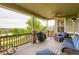 Charming covered deck with stone pillars, ceiling fan, and seating area with expansive view at 23503 E Minnow Dr, Aurora, CO 80016