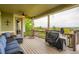 Inviting covered deck offers covered seating, stone pillars, ceiling fan, and grill at 23503 E Minnow Dr, Aurora, CO 80016