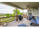 Relaxing covered deck with comfortable seating, ceiling fan, stone columns, and a stunning outdoor view at 23503 E Minnow Dr, Aurora, CO 80016