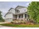 Beautiful two-story home featuring a covered porch, manicured lawn with mulch, and a convenient two-car garage at 23503 E Minnow Dr, Aurora, CO 80016