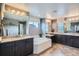 Bathroom features a large soaking tub, dark cabinets, and dual vanity sinks at 23503 E Minnow Dr, Aurora, CO 80016