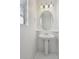 Small half bathroom with a pedestal sink, decorative mirror, and a tiled floor at 1272 Braewood Ave, Highlands Ranch, CO 80129