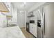 A well-equipped kitchen with modern stainless steel refrigerator, sleek countertops and white cabinetry at 7755 E Quincy Ave # 107D2, Denver, CO 80237