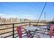 Cozy balcony view of the city skyline with red chairs and a bistro table at 5531 W 11Th Pl, Lakewood, CO 80214