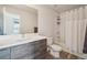 Modern bathroom with a gray wood vanity, white countertop, and a shower/tub combo at 5531 W 11Th Pl, Lakewood, CO 80214