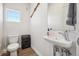 Small bathroom with a toilet, floating sink, and compact storage shelves, featuring modern fixtures at 5531 W 11Th Pl, Lakewood, CO 80214