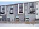 Modern townhome with gray and black siding, multiple balconies and snow-covered ground at 5531 W 11Th Pl, Lakewood, CO 80214