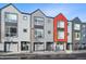 View of modern townhomes with gray siding and pops of color, highlighting their curb appeal at 5531 W 11Th Pl, Lakewood, CO 80214