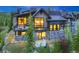 Luxury home with stone and wood exterior, lit windows, and hot tub visible at 52 West Point Lode # A, Breckenridge, CO 80424