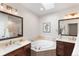 Luxurious bathroom with a soaking tub, dual vanities, and a skylight providing natural light at 1265 S Sherman St, Denver, CO 80210