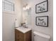 Stylish half bathroom with patterned wallpaper, a modern vanity, and decorative botanical art at 1265 S Sherman St, Denver, CO 80210