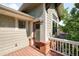 Charming home exterior with a cozy porch featuring a red door, brick accents, and light-green siding at 1265 S Sherman St, Denver, CO 80210