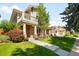 Attractive home exterior with a well-kept lawn, blossoming flowers, and a quaint front porch at 1265 S Sherman St, Denver, CO 80210