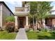 Charming brick home with a well-manicured lawn and inviting front porch with beautiful flowering plants at 1265 S Sherman St, Denver, CO 80210