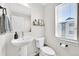 Modern powder room features a pedestal sink, toilet, and decorative shelf at 5387 Pierson Ct, Wheat Ridge, CO 80033