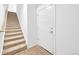 A stairway featuring carpeted steps, wood accents, and a modern door at 5387 Pierson Ct, Wheat Ridge, CO 80033