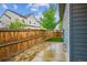 Fenced backyard features pavers with a small patch of green grass, and a young shade tree at 10360 E 57Th Pl, Denver, CO 80238